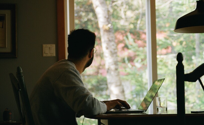 A man sitting at the desk and looking through the window