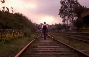 man walking on train tracks