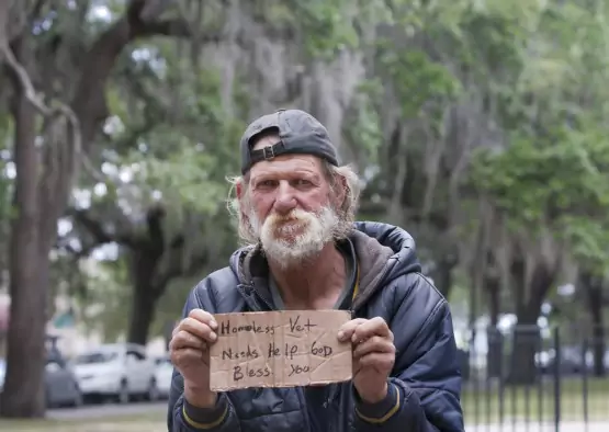 homeless man holding a sign