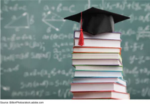 A stack of books in front of the blackboard