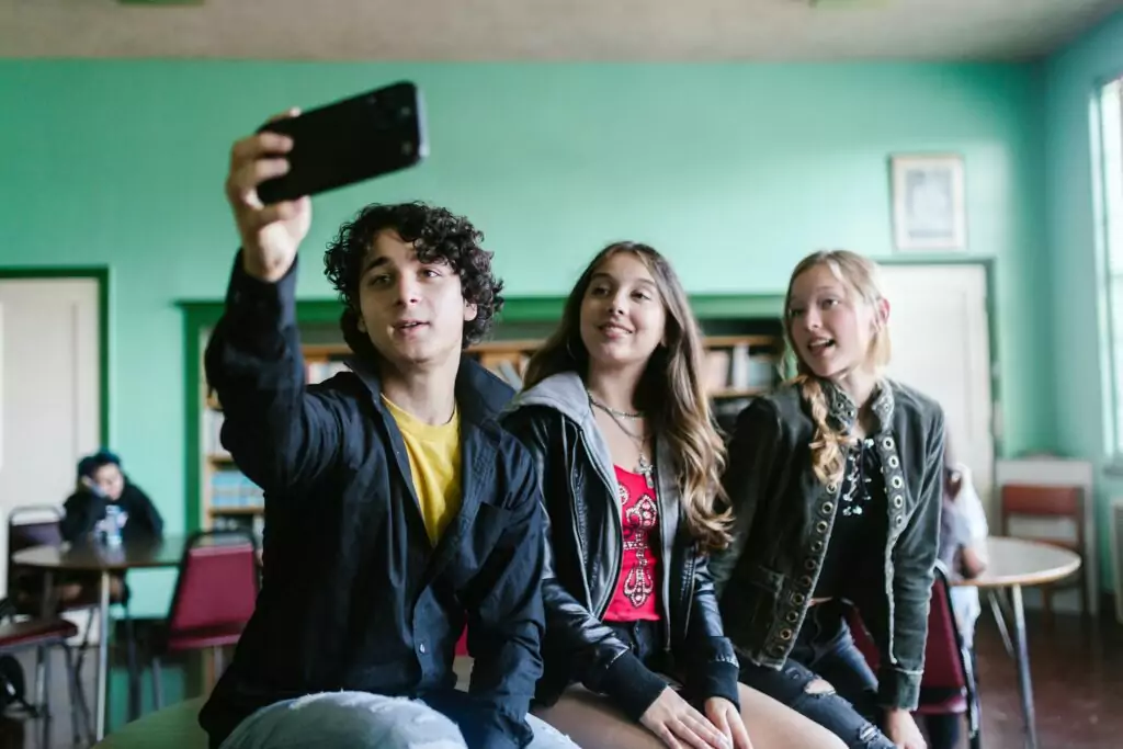 A photograph of three students using cellphones